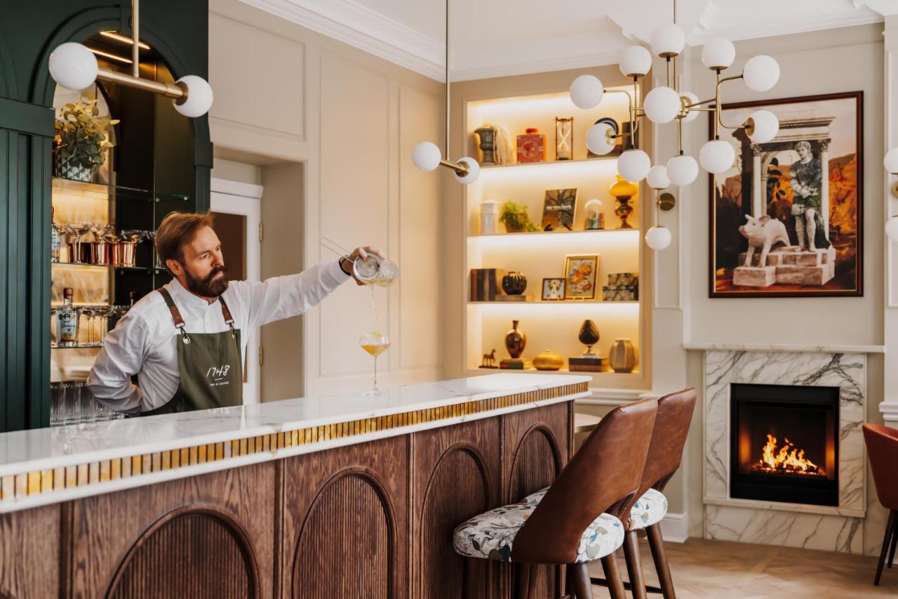 a man standing at a bar with a glass of wine at Parade Hotel Bath in Bath