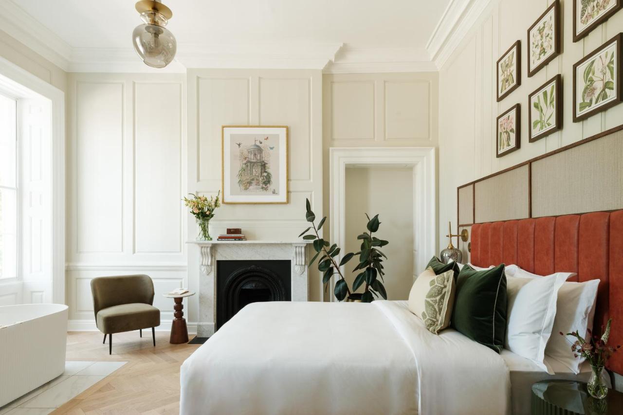 a bedroom with a large bed and a fireplace at Parade Hotel Bath in Bath